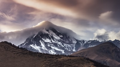 冰雪覆盖下的山在白天多云的天空
